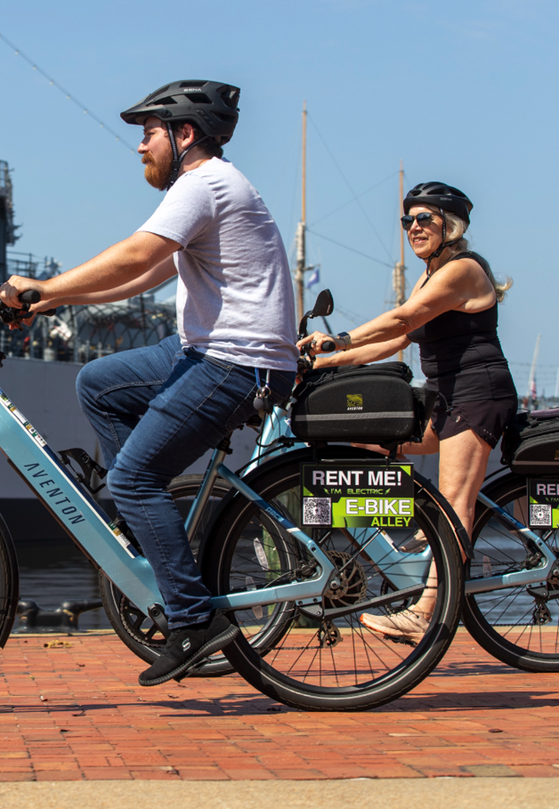 Couple riding e-bikes by the waterfront
